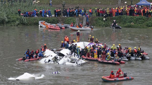 Emergency personnel try to extract passengers from the plane after it crashed in Taipei.