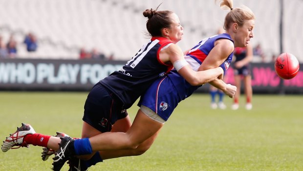 Daisy Pearce of the Demons tackles Katie Loynes of the Bulldogs during the women's exhibition match at the MCG on Sunday.