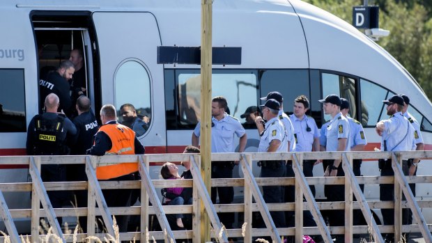 A small girl cries as she is removed by the police from a train in Rodbyhavn, Denmark.