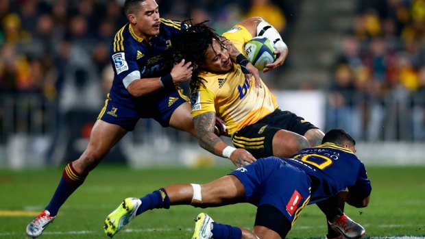 Dumped: Ma'a Nonu of the Hurricanes is tackled by Aaron Smith and Lima Sopoaga.