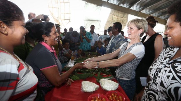Ms Bishop purchases eggplants in a market in Rakiraki. 