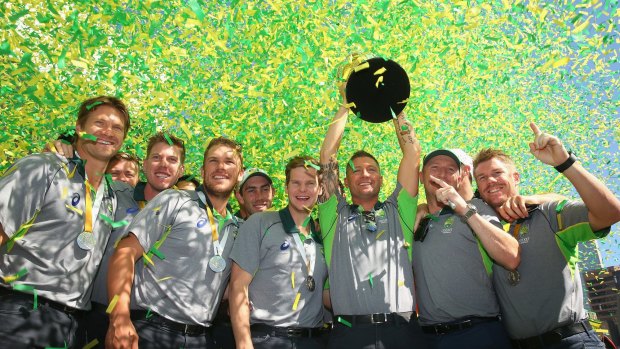The Australian cricket team poses with the World Cup trophy at Federation Square.