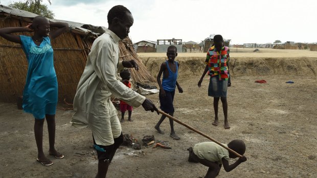 James Tut, 64 (2nd from left), who became blind in 2005, is led by a child inside the UN Bentiu Protection of Civilians (POC) site.