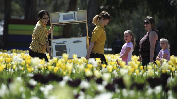 IKEA workers Rebecca Smith and Casey Gill "hide" a Duktig (children's kitchen) near their
Floriade display.