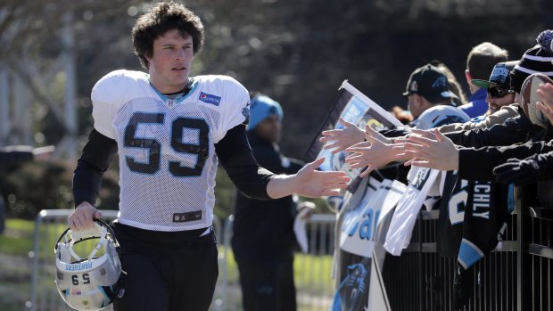 Carolina Panthers' Luke Kuechly greets fans as he arrives before practice.