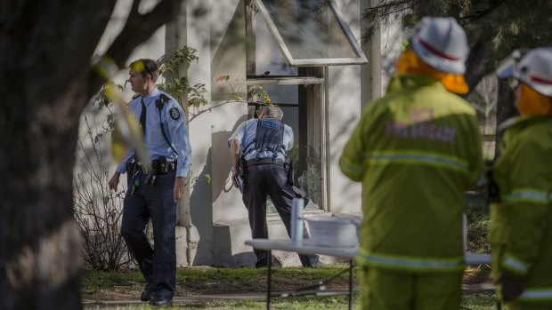 Emergency services inspect the Lyneham Flats after a fire started inside a unit on Thursday. 
