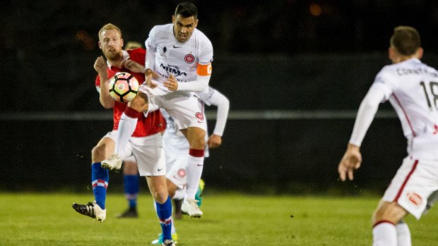 Canberra FC's Ian Gram and Wanderers player Dimas Delgado clash.