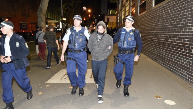 A man is arrested outside the ABC's headquarters in Ultimo on Monday night, in demonstrations for and against Pauline Hanson.