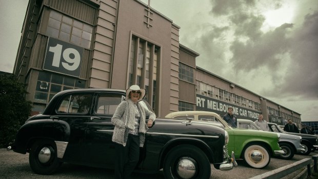 Margaret McKay rests on her 1951 Hillman Minx sedan in front of the old factory at 19 Salmon Street.