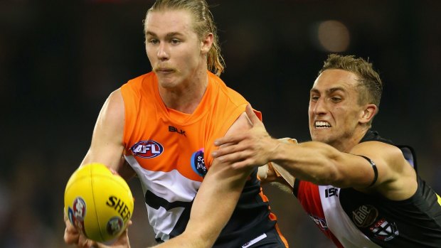 GWS' Cam McCarthy handballs under pressure from Luke Dunstan.