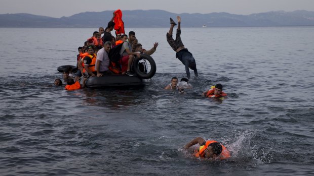Refugees jump into the sea from a dinghy off the coast of Lesbos last week.