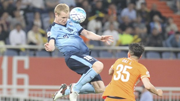 Matthew Simon of Sydney FC and Dai Lin of Shandong Luneng compete for the ball during the first leg of their round of 16 cash in Jinan.