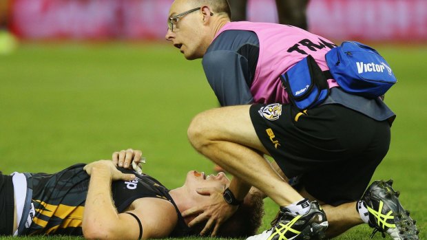 Floored: Richmond's Jacob Townsend receives attention after a collision with Port Adelaide's Hamish Hartlett.