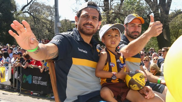 Cyril Rioli and Paul Puopolo of the Hawks   wave to the crowd during Friday's grand final parade.