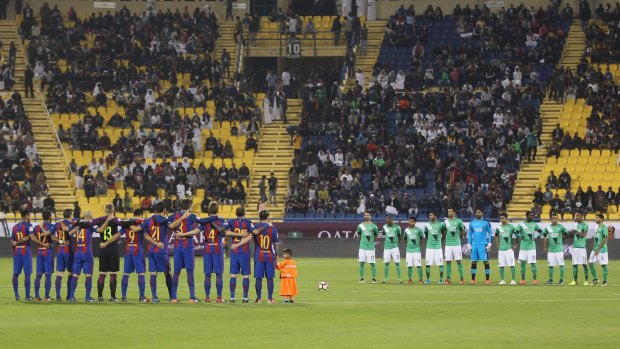 Teams observe a minute's silence during the Qatar Airways Cup match between FC Barcelona and Al-Ahli Saudi FC on December 13, 2016 in Doha, Qatar.