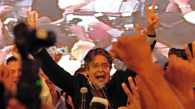 Guillermo Lasso flashes victory signs as he awaits final election results in Guayaquil, Ecuador, on Sunday.