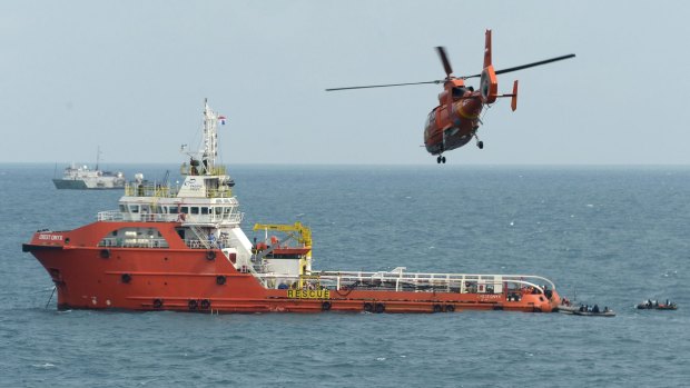 Searching for the main fuselage ... An Indonesian rescue helicopter flies over the Crest Onyx ship as divers search below. 