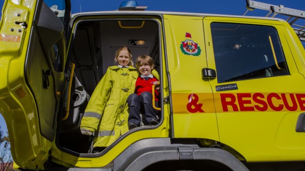 Serena Edwards and Lucas Gill, both 5, enjoy a look inside a Fire and Rescue vehicle during Monday's fire safety session at Brindabella Christian College.