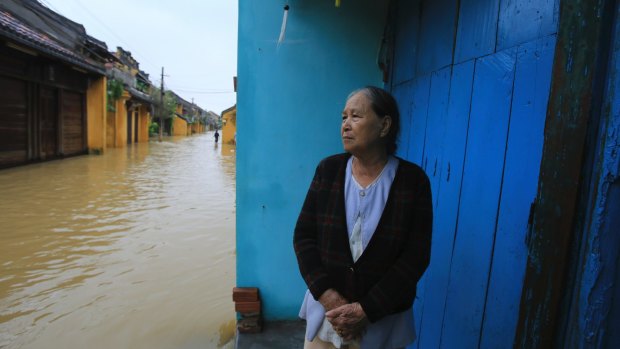 Nguyen Thi Hong looks out to flooded street in front of her house in Hoi An, Vietnam.