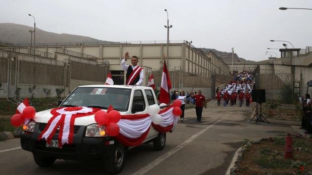 An inmate dressed to represent Peru's then president Ollanta Humala, waves during an Independence Day parade inside the Ancon II prison on the outskirts of Lima  in July.