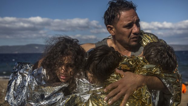 A man and three children arrive on the Greek island of Lesbos after a rough crossing from Turkey.
