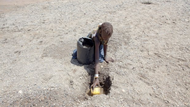 A girl digs in a river bed for water in northern Kenya. More than 23 million people in east Africa are facing a critical shortage of water and food, a situation made worse by climate change.