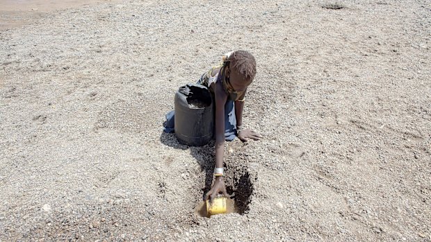 A girl digs in a river bed for water in northern Kenya. More than 23 million people in east Africa are facing a critical shortage of water and food, a situation made worse by climate change.