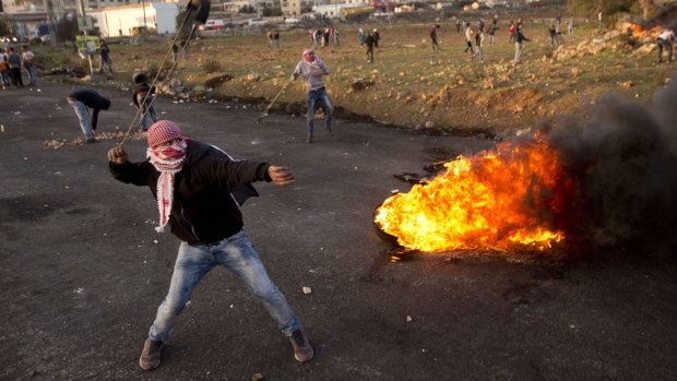 Palestinian protesters throw stones at Israeli troops in the West Bank city of Ramallah on Sunday. 