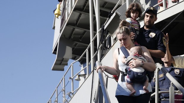 A woman evacuated from Libya carries her baby upon arrival in Piraeus, near Athens, Greece.