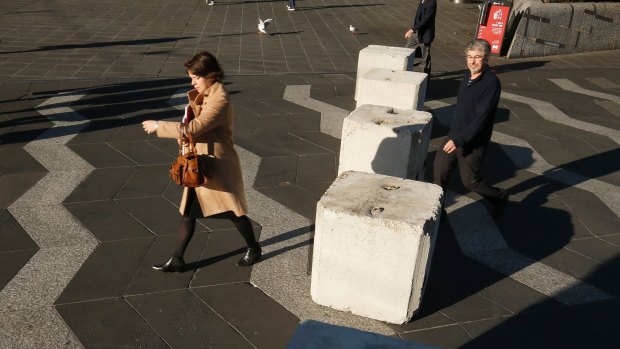 Pedestrians pass bollards in Queensbridge Square on Friday.