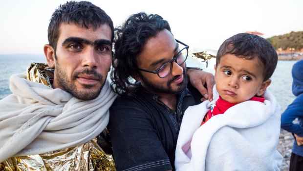 Helping hand: Shaan Ali, middle, with Syrian refugee Hasan and his son on the Greek island of Lesbos.