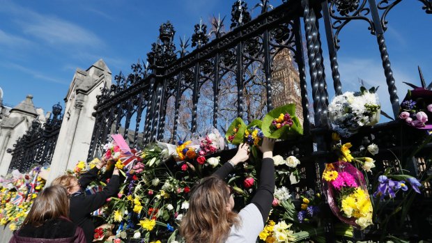 People place flowers outside Britain's Parliament, for the victims of the Westminster attack in March.