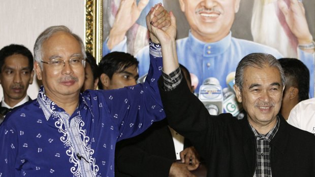 Former Malaysian Prime Minister Abdullah Ahmad Badawi holds hands with his then deputy Najib Razak (left) in 2008.
