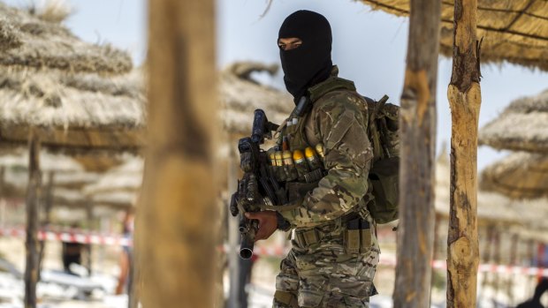 A member of Tunisia's special forces inspects the beachside of the Imperial Marhaba resort.