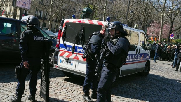 Armed police officers patrol in Paris after a letter bomb exploded at the IMF.
