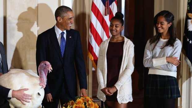 President Obama "pardons the turkeys" with his daughters Sasha and Malia. 