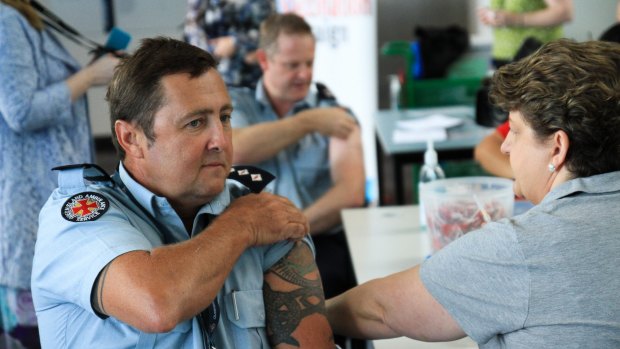 Critical care paramedic Gavin Farry gets his flu vaccination at the Royal Brisbane and Women's Hospital on Thursday.