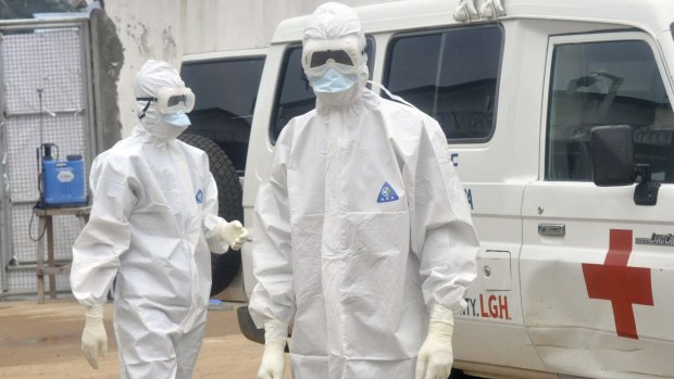 Health workers in Liberia prepare to remove the body of an Ebola victim.