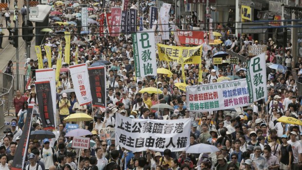 Hundreds of protesters march on a downtown street during an annual pro-democracy protest in Hong Kong in July 2016.