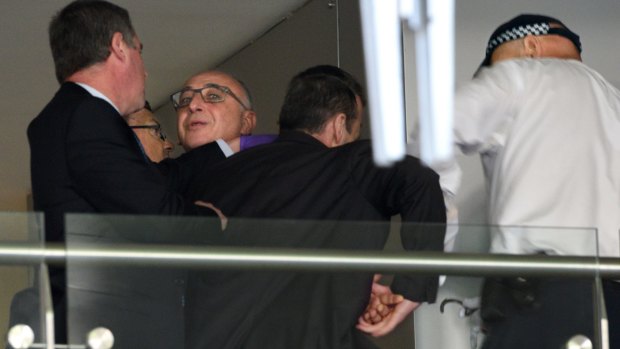 Police officers handcuff Michael Teplitsky (in glasses) during a scuffle amid a raid on his Double Bay office.