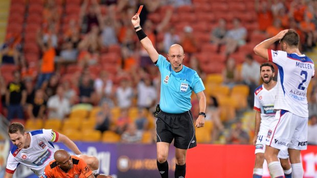 Referee Strebre Delovski gives a red card to Nigel Boogaard of the Jets.