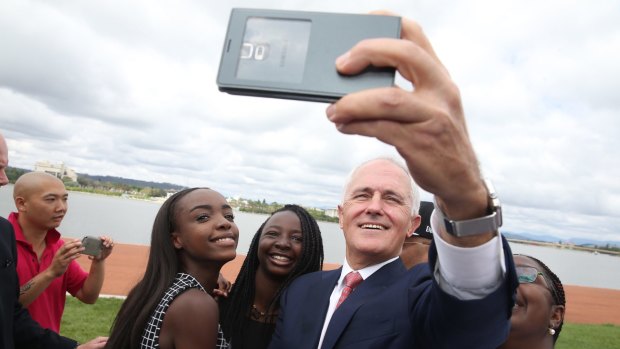 Prime Minister Malcolm Turnbull takes a selfie with new Australian citizens Lydia Banda-Mukuka and Chilandu Kalobi Chilaika after the citizenship ceremony.