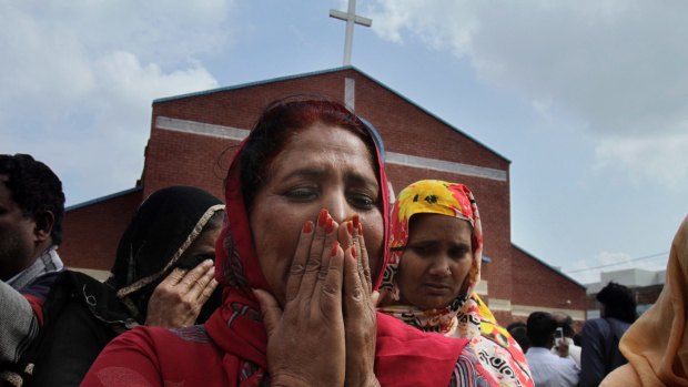 Pakistani Christian women mourn as they gather at a church damaged from a suicide bombing attack that killed 15 people in Lahore, Pakistan on Sunday, March 15, 2015.