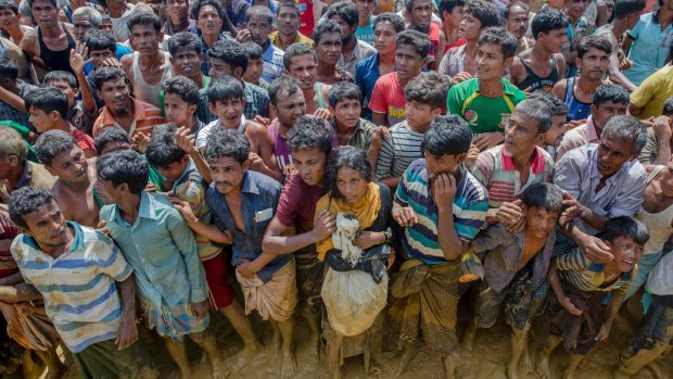 Rohingya Muslims, who crossed over from Myanmar into Bangladesh, wait to receive handouts near Balukhali refugee camp on Thursday.