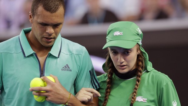 Jo-Wilfried Tsonga helps injured ballgirl Giuliana off the court at last year's Australian Open.