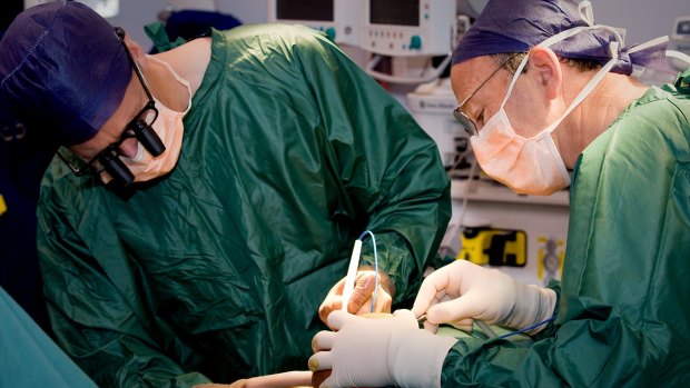 Surgeons Andrew Greensmith (left) and Tony Holmes perform an operation to separate a pair of Bangladeshi twins  joined at the head, at Melbourne's Royal Children's Hospital.