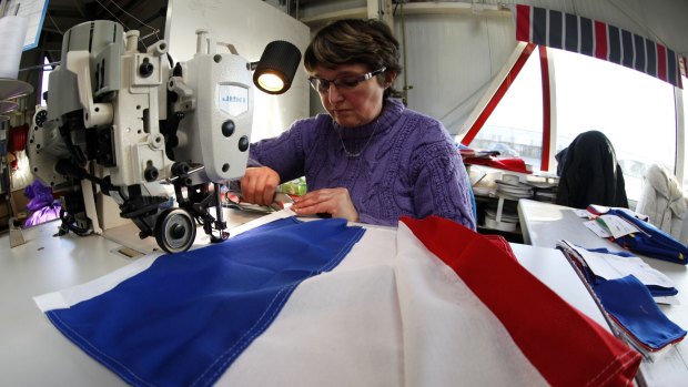 Patricia Toillon, 50, works on a French flag at the Doublet factory in Avelin, near Lille, this week. 