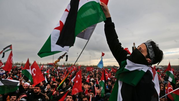 Protesters wave Turkish and Palestinian flags, as they participate in a rally against Donald Trump's decision to recognise Jerusalem at the capital of Israel.