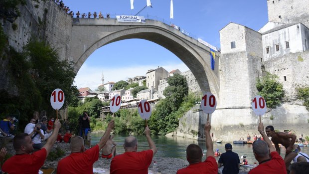 Divers wait to jump from Mostar bridge during 454th traditional diving competition.