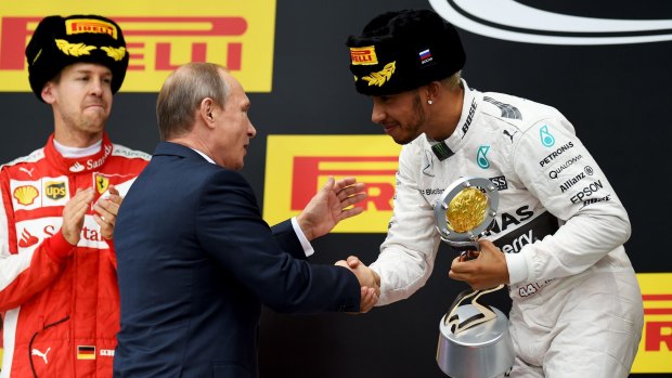 Mercedes driver Lewis Hamilton shakes hands with Russian president Vladimir Putin after winning the Russian Grand Prix on Sunday.